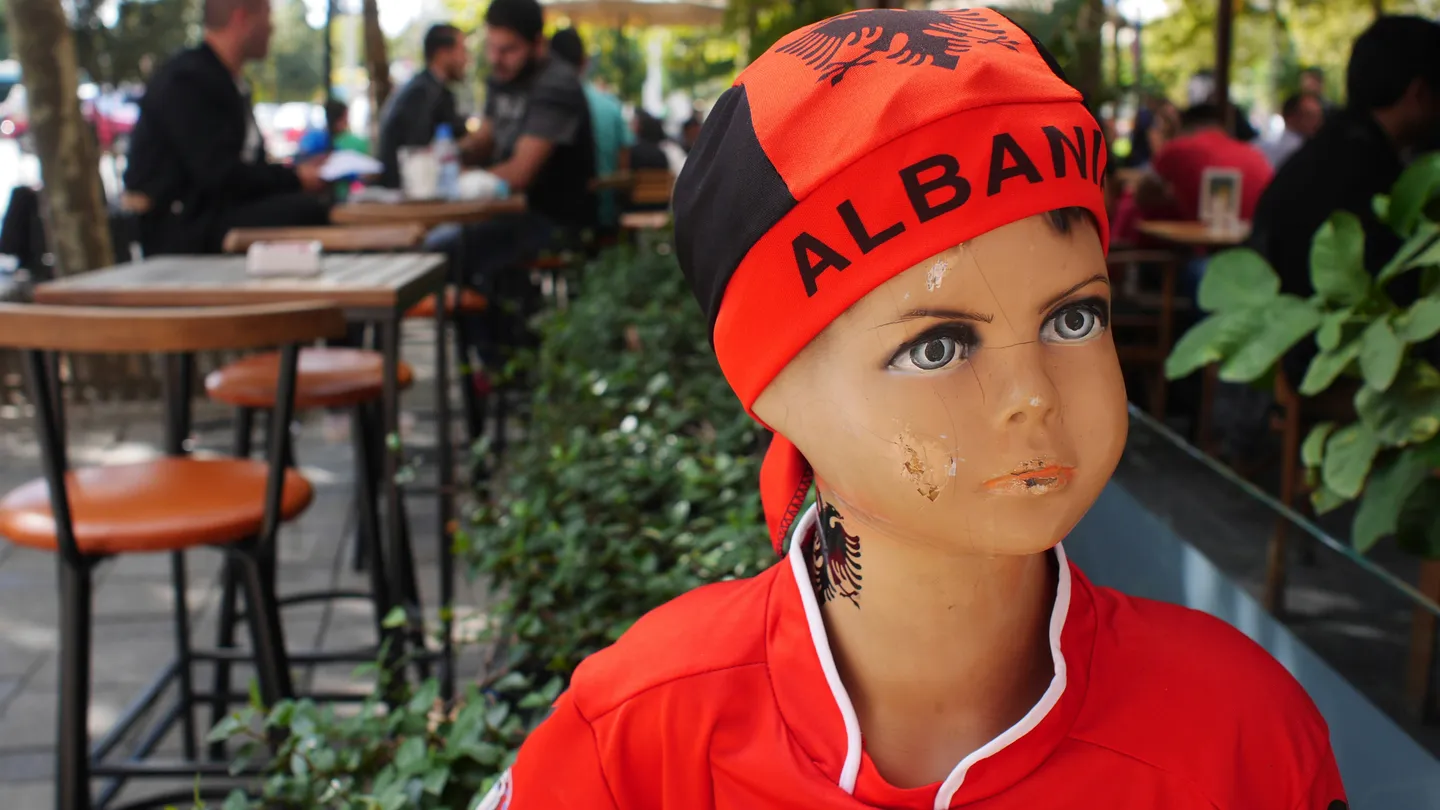 A shop mannequin on a Tirana cafe terrace wearing an Albania bandana and red national team shirt