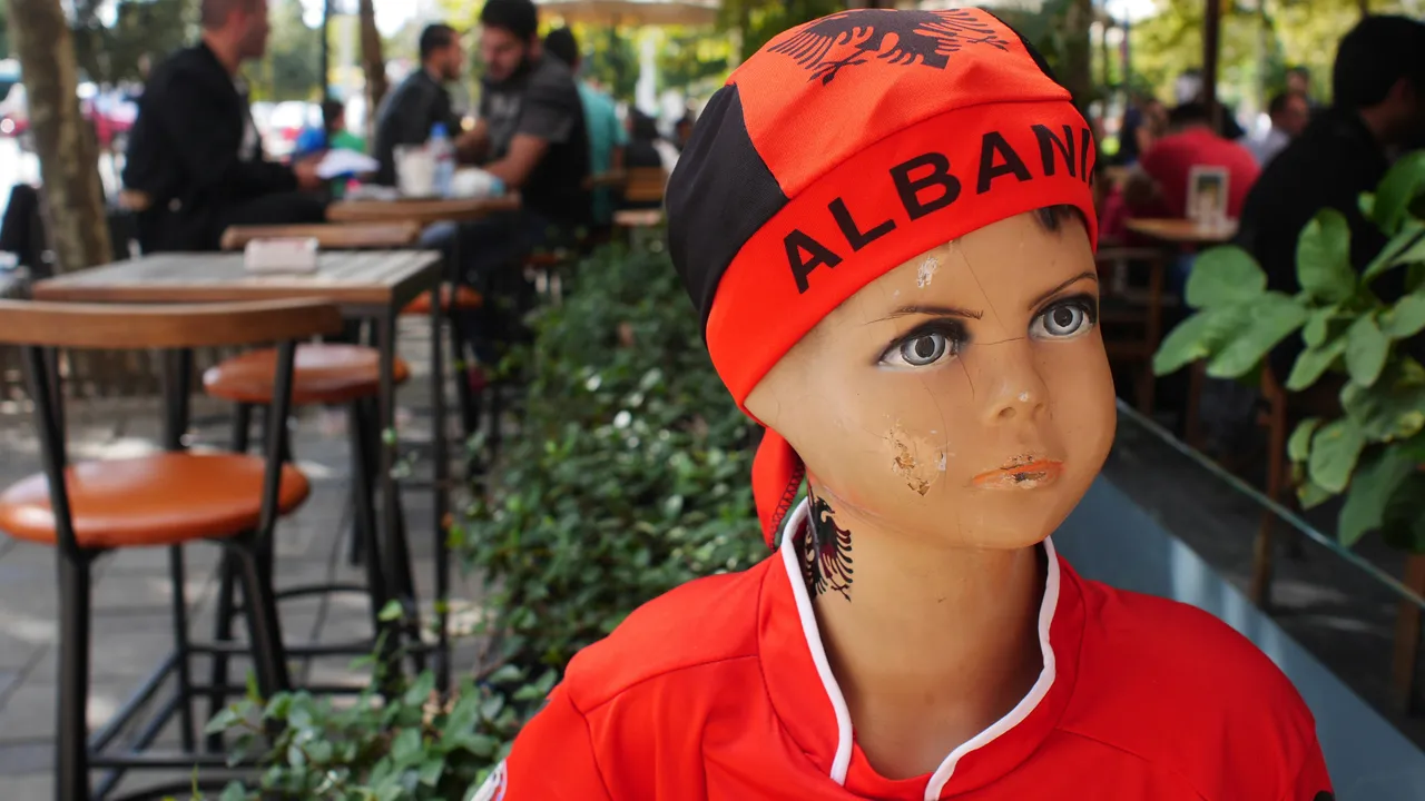 A shop mannequin on a Tirana cafe terrace wearing an Albania bandana and red national team shirt