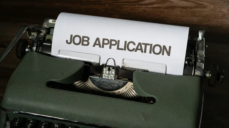 A green typewriter with a job application printed on it