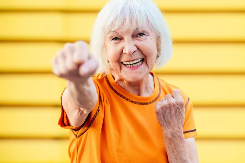 A white-haired grandma doing a superwoman pose
